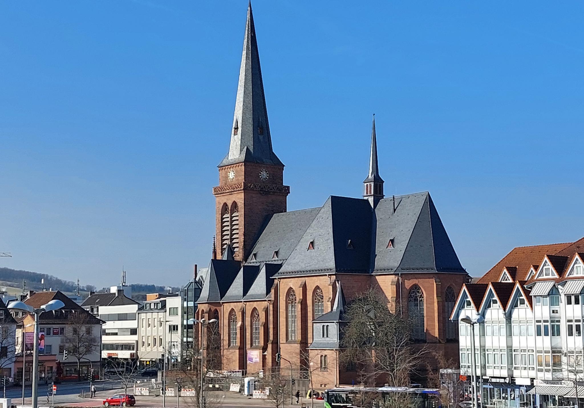 Das Bild zeigt die Hl.-Kreuz-Kirche mit umgebenden Gebäuden aus der Richtung des Fahrradparkhauses