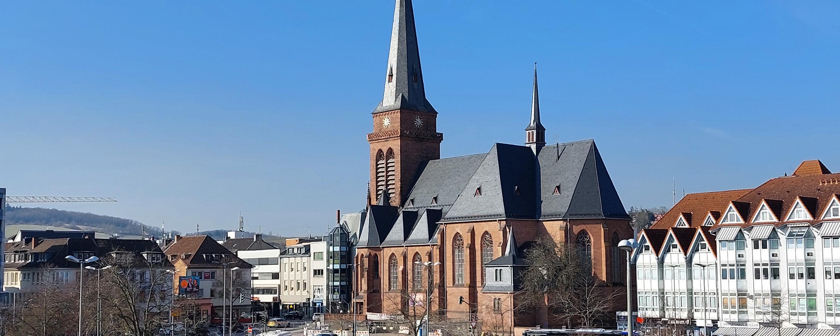 Das Bild zeigt die Hl.-Kreuz-Kirche mit den umgebenden Gebäuden aus der Richtung  des Fahrradparkhauses