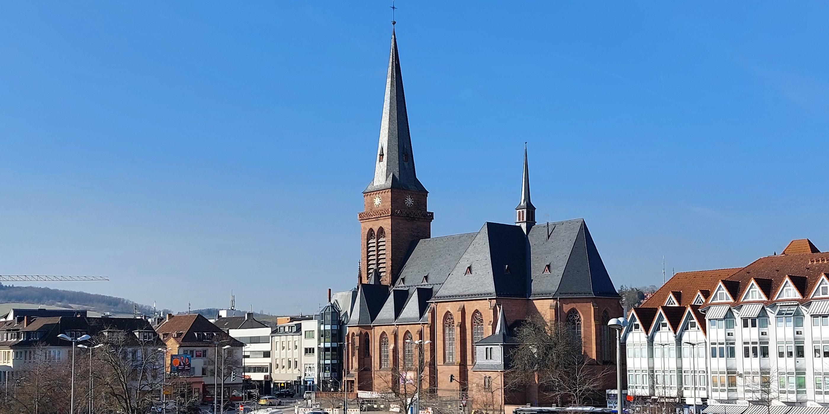 Das Bild zeigt die Hl.-Kreuz-Kirche mit den umgebenden Gebäuden aus der Richtung  des Fahrradparkhauses