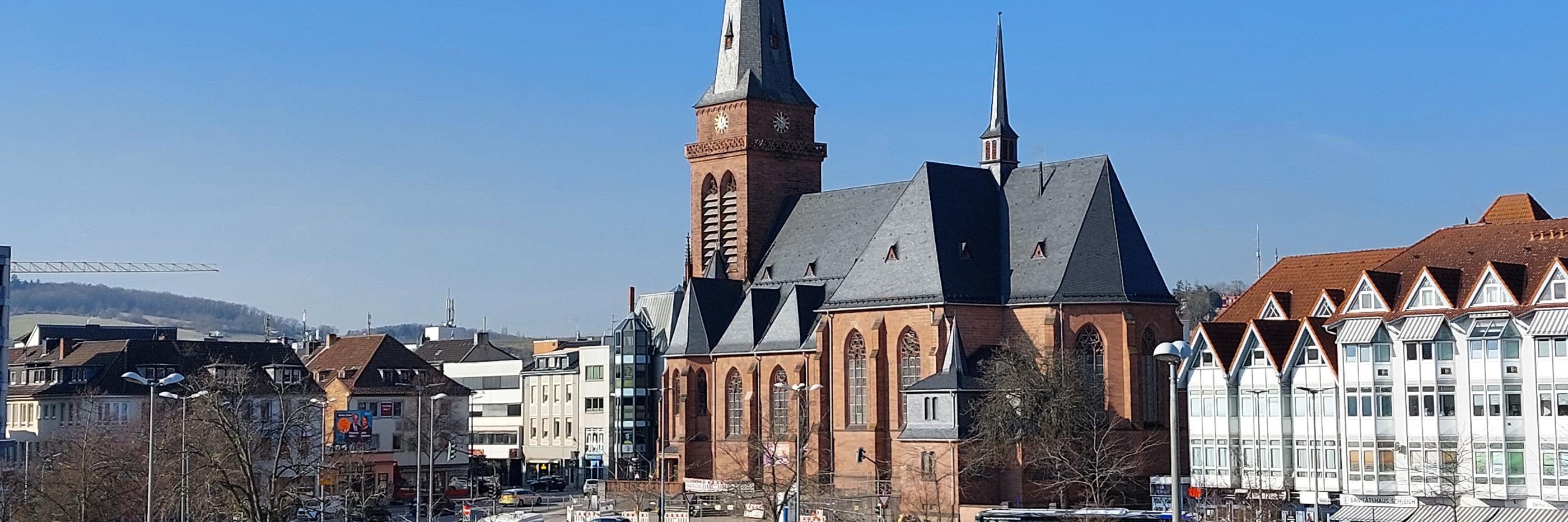 Das Bild zeigt die Hl.-Kreuz-Kirche mit den umgebenden Gebäuden aus der Richtung  des Fahrradparkhauses