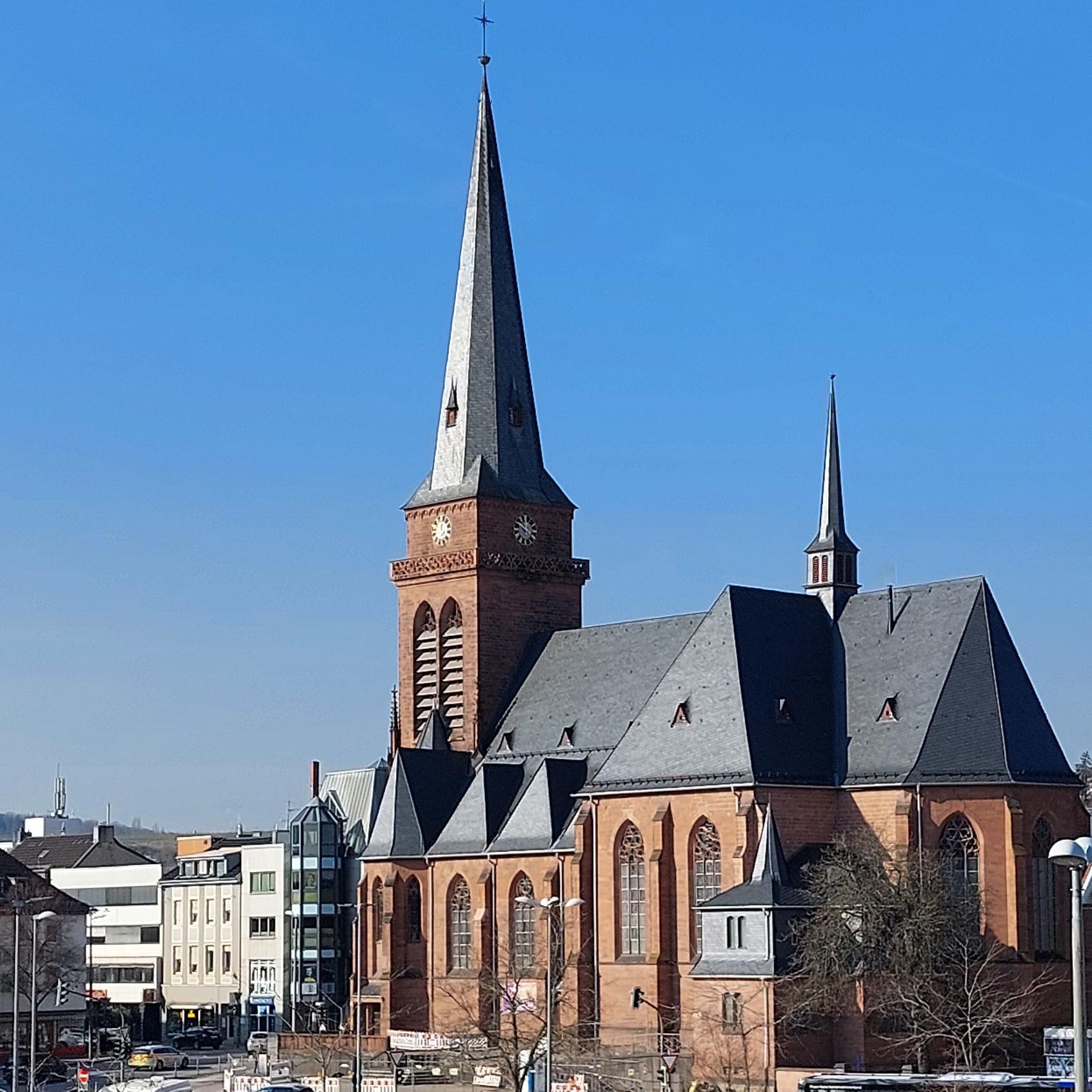 Das Bild zeigt die Hl.-Kreuz-Kirche mit den umgebenden Gebäuden aus der Richtung  des Fahrradparkhauses