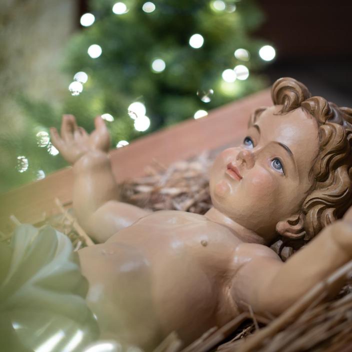 Das Bild zeigt das Christkind in einer Krippe liegend. (c) Markus Weinländer In: Pfarrbriefservice.de Das Bild zeigt das Christkind in einer Krippe liegend.